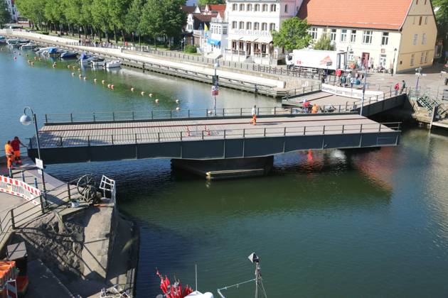 News Bilder des Tages Blick am Donnerstag (16.05.2024) im Ostseebad Warnemünde, ein Ortsteil der Hanse- und Universitätsstadt Rostock, auf die teilweise geöffnete Drehbrücke über den Alten Strom. An der Brücke wurden im Verlauf des Tages Reparaturarbeiten durchgeführt. Dazu wurde an einigen Stellen der Korrosionsschutz erneuert. Dahingehend wurde die Brücke am Vormittag in zwei Phasen gedreht und für den öffentlichen Verkehr gesperrt. So mussten die Passanten zur besten Frühstückszeit entweder die Brücke umlaufen oder an den beiden Zugängen solange warten bis das Bauwerk wieder seine ursprüngliche Position eingenommen hat. Daraufhin sammelten sich an den beiden Absperrungen immer wieder zahlreiche Schaulustige. Zumal das Öffnen Brücke nur sehr selten passiert.