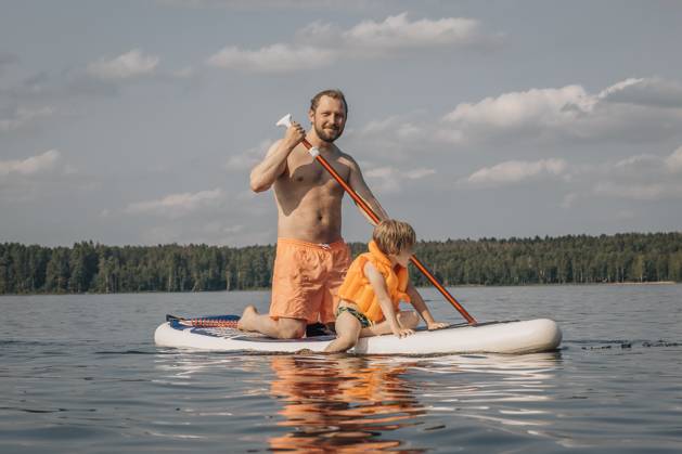 Shirtless man with son on SUP board in sea at sunny day model released, Symbolfoto, EVKF00132