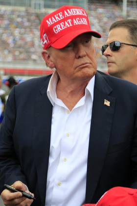 CHARLOTTE, NC - MAY 26: Former President of the United States of America Donald Trump signs an autograph for a fan on pit road prior to the running of the NASCAR Cup Series Coca-Cola 600 on May 26, 2024 at Charlotte Motor Speedway in Charlotte, NC. (Photo by Jeff Robinson Icon Sportswire) EDITORIAL USE ONLY Icon1045686857