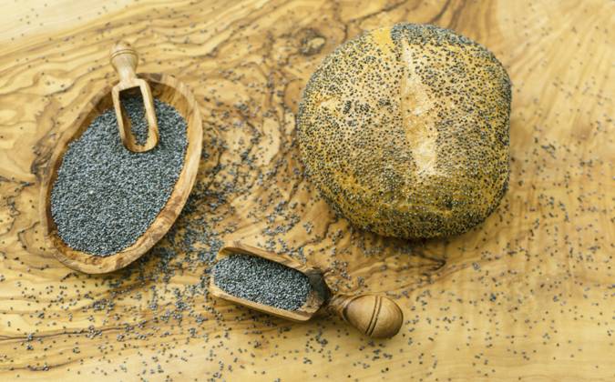 IMAGO Creative: Food, Mohn Mohnbroetchen und Mohnsamen in Holzschale und auf Holzschaeufelchen Poppy seed rolls and poppy seeds in a wooden bowl and on a wooden scoop BLWS709976