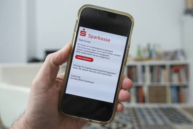 Betrügerische Phishing email auf einem Mobiltelefon die dazu auffordert ein wichtiges Update für die Banksoftware der Sparkasse durchzuführen