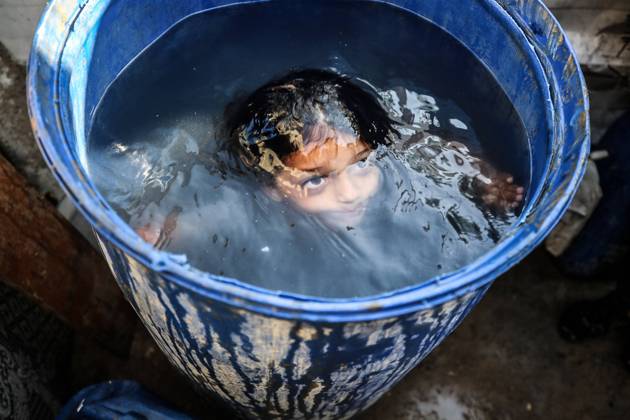 Bilder des Jahres 2024, News 06 Juni News Themen der Woche KW24 News Bilder des Tages Nahostkonflikt, Gaza, Hitzewelle in Deir al Balah Heat Wave In Deir al-Balah A displaced Palestinian boy is washing himself with water in front of his tent during a heatwave in Deir al-Balah, in the central Gaza Strip, on June 11, 2024, amid the ongoing conflict between Israel and the Palestinian Hamas militant group. Gaza Palestine  Copyright: xMajdixFathix originalFilename: fathi-notitle240611_np0Nc.jpg