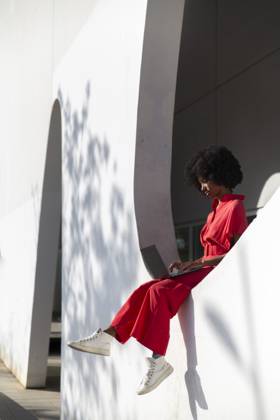 Freelancer using laptop and sitting on wall of modern building model released, Symbolfoto, PCLF01100