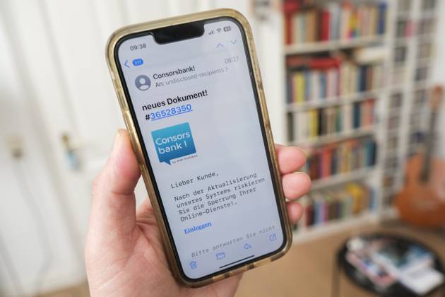 Betrügerische Phishing email auf einem Mobiltelefon die dazu auffordert ein wichtiges Update für die Banksoftware derConsors Bank durchzuführen