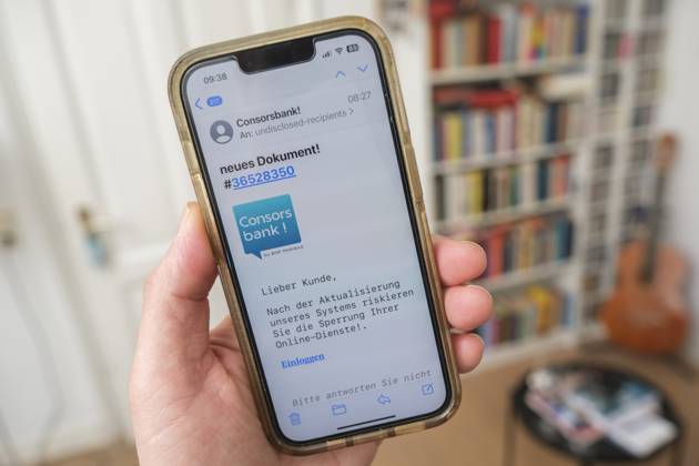 Betrügerische Phishing email auf einem Mobiltelefon die dazu auffordert ein wichtiges Update für die Banksoftware derConsors Bank durchzuführen
