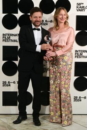 Director and actor Jiri Madl, left, and producer Monika Kristlova pose in front the photo wall with their Pravo Audience Award for the film Waves after the closing awards ceremony of the 58th Karlovy Vary International Film Festival, in Karlovy Vary, Czech Republic, on July 6, 2024. (CTKxPhoto SlavomirxKubes) CTKPhotoP2024070605420  CTKPhotoP2024070605420