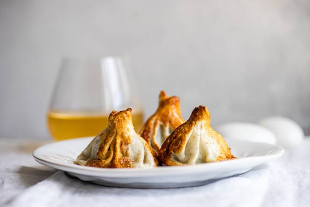 IMAGO Creative, Food, Dumplings Authentic Georgian khinkali dumplings served on a white plate, expertly cooked A clear glass of white wine complements the scene, heightening the culinary appeal Model Released AnnaBogush_ID22388_654127_006 Copyright: xAnnaxBogushx