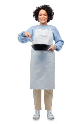 culinary and people concept - happy smiling woman in apron with frying pan and spoon cooking food over white background. happy woman in apron cooking food in frying pan ,model released, Symbolfoto