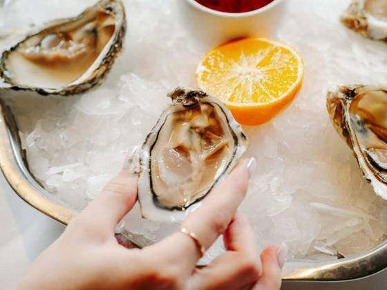 Woman having oysters at table, Woman having oysters at table. Fresh oysters on large plate with ice and lemon. Healthy food, gourmet food, restaurant food. Mediterranean cuisine, girl eats, oysters on ice, Woman having oysters at table. Fresh oysters on large plate with ice and lemon. Healthy food, gourmet food, restaurant food. Mediterranean cuisine, girl eats, oysters on ice, 25.02.2024, Copyright: xFascinadorax Panthermedia36817010.jpg
