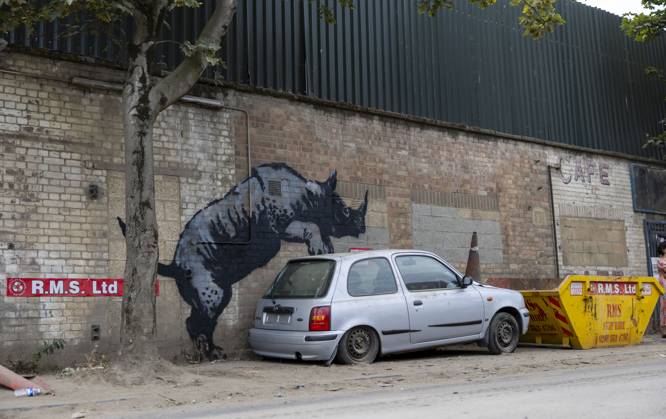 Bilder des Jahres 2024, News 08 August News Themen der Woche KW33 News Bilder des Tages Banksy has revealed a cheeky new rhino mural in Charlton, London. It™s eighth piece of animal artwork in eight days. The latest image shows the animal mounting an old silver Nissan Micra that has a traffic cone on its bonnet, apparently to resemble another rhinoceros.  Copyright: xBenxPetersx