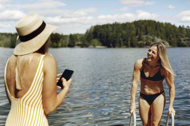 Woman photographing friend while bathing in lake , model released Copyright: xJohnerxImagesx , johner2499947.jpg 