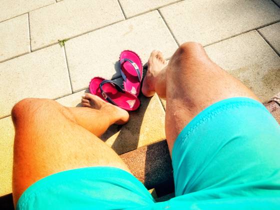 01.09.2024, Schwimmen im Freibad Bad Wörishofen (Bayern), ein Mann sitzt an der Bank im Freibad, vor sich seine Badeschlappen. (Model Release vorhanden) 01.09.2024, Relaxen im Freibad 01.09.2024, Relaxen im Freibad