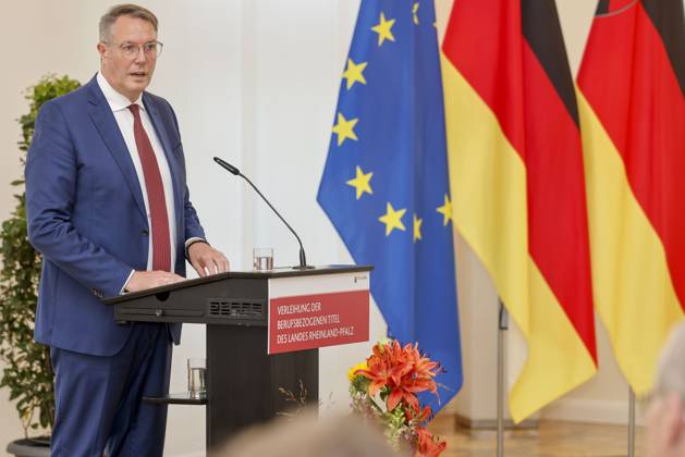 Der rheinland-pfälzische Ministerpräsident Alexander Schweitzer am Rednerpult vor Fahnen in der Staatskanzlei Rheinland-Pfalz. Rede anlässlich der verleihung berufsbezogener Titel des Landes. 03.09.24