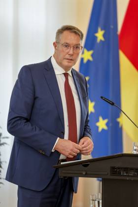 Der rheinland-pfälzische Ministerpräsident Alexander Schweitzer am Rednerpult vor Fahnen in der Staatskanzlei Rheinland-Pfalz. Rede anlässlich der verleihung berufsbezogener Titel des Landes. 03.09.24