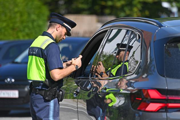 Grenzpolizist,Polizist kontrolliert die Papiere einer Person,Fahrer. Grenzpolizisten kontrollieren Fahrzeuge. Joachim HERRMANN (Innenminister Bayern), Justizminister Georg EISENREICH und die Bayerische Grenzpolizei informieren ueber verstaerkten Grenzschutz am 04.09.2024 am Grenzuebergang Burghausen Neue Bruecke zur Bekaempfung illegaler Migration,