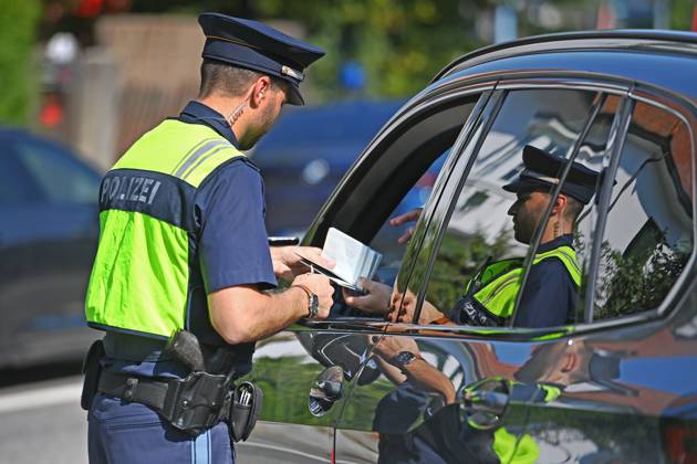 Grenzpolizist,Polizist kontrolliert die Papiere einer Person,Fahrer. Grenzpolizisten kontrollieren Fahrzeuge. Joachim HERRMANN (Innenminister Bayern), Justizminister Georg EISENREICH und die Bayerische Grenzpolizei informieren ueber verstaerkten Grenzschutz am 04.09.2024 am Grenzuebergang Burghausen Neue Bruecke zur Bekaempfung illegaler Migration,