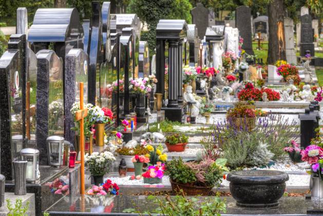 Grabsteine Bunt geschmückte, mit vielen Blumen dekorierte Grabsteine mit nicht identifizierbaren Namen in Schrägansicht mit Fluchtpunktperspektive auf dem Wiener Zentralfriedhof Copyright: xZoonar.com FrankxWagnerx 22148907