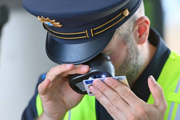 Grenzpolizist,Polizist kontrolliert die Echtheit einer Fahrerlaubnis,Fuehrerschein. Grenzpolizisten kontrollieren Fahrzeuge. Joachim HERRMANN (Innenminister Bayern), Justizminister Georg EISENREICH und die Bayerische Grenzpolizei informieren ueber verstaerkten Grenzschutz am 04.09.2024 am Grenzuebergang Burghausen Neue Bruecke zur Bekaempfung illegaler Migration,