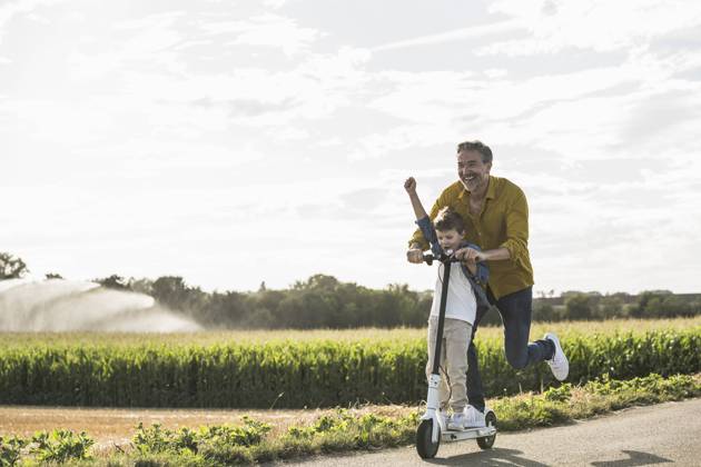 Boy having fun and riding push scooter with grandfather on road model released, Symbolfoto, UUF30050