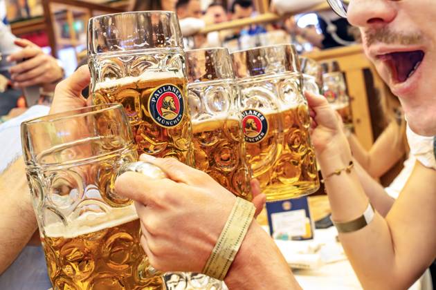 Wiesnbesucher stoßen im Paulaner-Festzelt mit ihrer Maß Bier an, Oktoberfest, München, September 2024 Deutschland, München, September 2024, Wiesnbesucher stoßen im Paulanerzelt mit ihrer Maß Bier an, haben riesigen Durst, Biertrinker, Maßkrüge, Bierpreis im Festzelt 15,10 Euro, Oktoberfest, typisch bayerisch, Volksfest, Bayern,