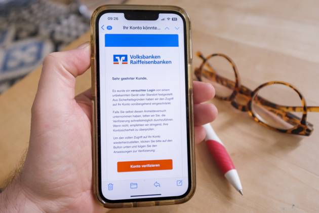 Betrügerische Phishing email auf einem Mobiltelefon die eine angebliche Aktivität bei einem Konto der Volksbanken Raiffeisenbanken meldet