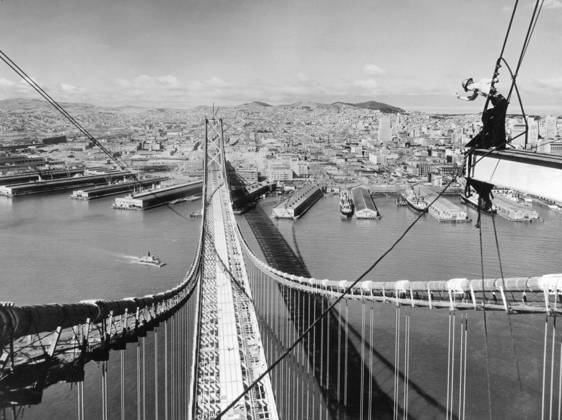 Orig. caption... AUTOS WILL SOON ROLL OVER FRISCO BAY and here s the way automobiles will be entering San Francisco, after Nov. 12, 1936, when the San Francisco-Oakland Bay Bridge, world s largest span, will open to traffic. The view, taken from the suspension tower, shows paving forms laid in the center lane, and floor steel in place for the upper deck which will carry six lanes of automobile traffic. The lower deck will accommodate two interurban train tracks, and three lanes for trucks. The San Francisco waterfront, over which the bridge passes is in the foreground, with the business section to the right. Twin Peaks to the rear, and in the distance, the Golden Gate. The bridge will be eight and one-quarter miles long, and cost $77,200,0 Copyright: xx SAN FRANCISCO-OAKLAND BAY BRIDGE