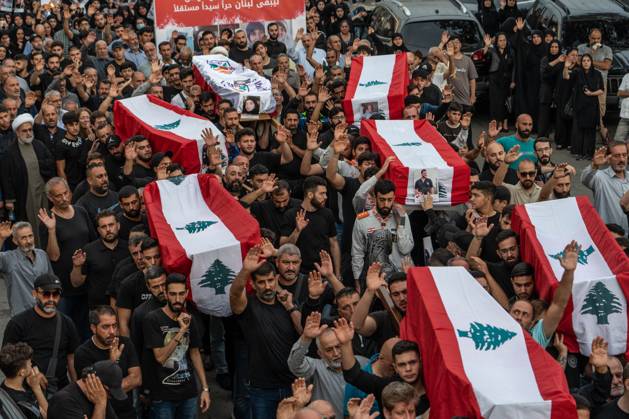 News Bilder des Tages October 14, 2024, Maaysrah, Maaysrah, Lebanon: A large crowd of people carry flag draped coffins during a mass funeral service for those killed in an Israeli airstrike. 15 people died in the attack, according to the Lebanese Ministry of Health. Maaysrah Lebanon - ZUMAw401 20241014_znp_w401_008 Copyright: xTimothyxWolferx