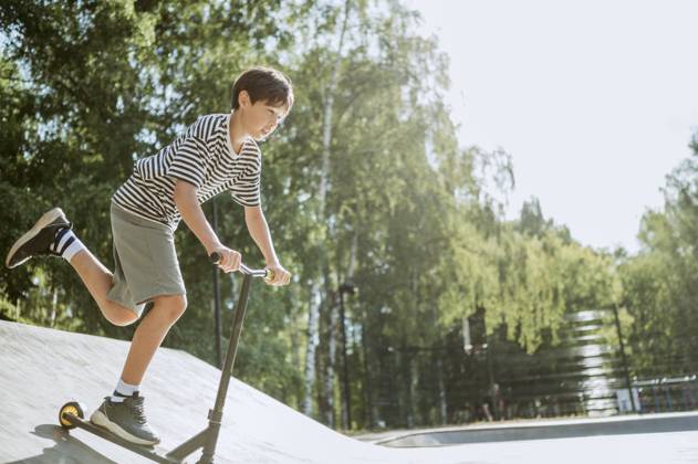 Pre-adolescent boy riding push scooter on sunny day model released, Symbolfoto, ANAF03914