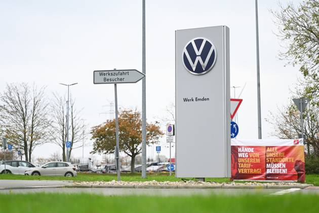 Volkswagen-Werk Emden in der Krise. Vor dem Volkswagen-Werk Emden steht ein Schild mit der Aufschrift Werk Emden. Daneben stehen Banner der IG-Metall Küste. Europas größter Autobauer möchte drei Werke in Deutschland schließen und Zehntausende Mitarbeiter entlassen. Emden Niedersachsen Deutschland