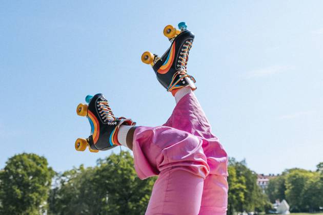 Low section of woman wearing rainbow striped roller skates under blue sky Sweden, Stockholm, model released Copyright: xMaskotx , MA113134 MA113134