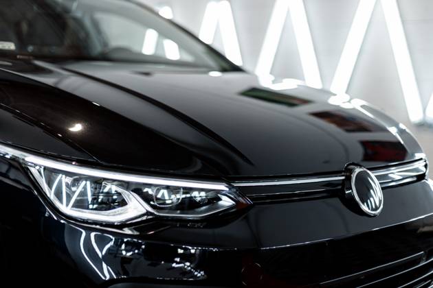 Schwarzes Auto mit optischen Scheinwerfern steht in der Garage. Autowäsche. Aufarbeitung. Reparatur