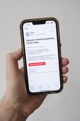 Betrügerische Phishing email auf einem Mobiltelefon die dazu auffordert die eigne Adresse bei dem Paketzusteller DDP zu aktualisieren