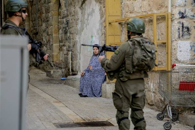 Bilder des Jahres 2024, News 12 Dezember News Themen der Woche KW52 News Bilder des Tages Israeli Security Measures in Hebron Old City A Palestinian woman talks to Israeli army soldiers standing guard as Israeli Jewish settlers tour the old market in the city of Hebron in the occupied West Bank on December 28, 2024. Hebron West Bank Palestinian territories Copyright: xMosabxShawerx
