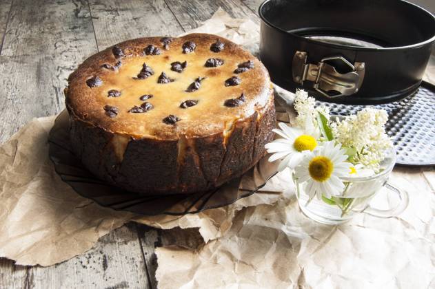Cheesecake on an old table with a bouquet of daisies and a form for baking. Near wrapping paper. Retro style. From the series Still Life with cheesecake , 46003260.jpg, celebrations, dessert, chocolate, food, sweet, flower, cake, cheesecake, cheese, baking, decoration, table, gourmet, single, eating, plate, temptation, brown, traditional, biscuit, easter, cherry, refreshment, pastry, white, dishware, homemade, close-up, colors, cream, freshness, portion, tablecloth, nobody, yellow, life, breakfast, spoon, wood, part, amomile, glass cup, bouquet, packaging paper, still life, retro, horizontal RECORD DATE NOT STATED