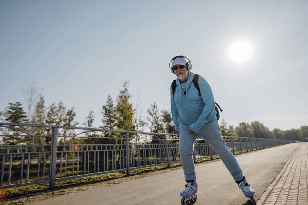 Cheerful senior man riding roller skates in park model released, Symbolfoto, IEF00796
