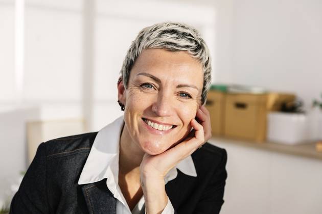 Smiling businesswoman with hand on chin at office model released, Symbolfoto property released, XLGF03473