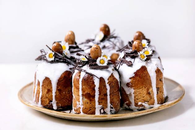 Hausgemachter traditioneller orthodoxer Osterkuchen traditioneller Kulich Homemade traditionla Easter kulich cake with chocolate nests and eggs on ceramic plate over white texture background. Traditional ortodox easter Russian Ukrainian bake Copyright: xZoonar.com NATASHAxBREENx 22727611
