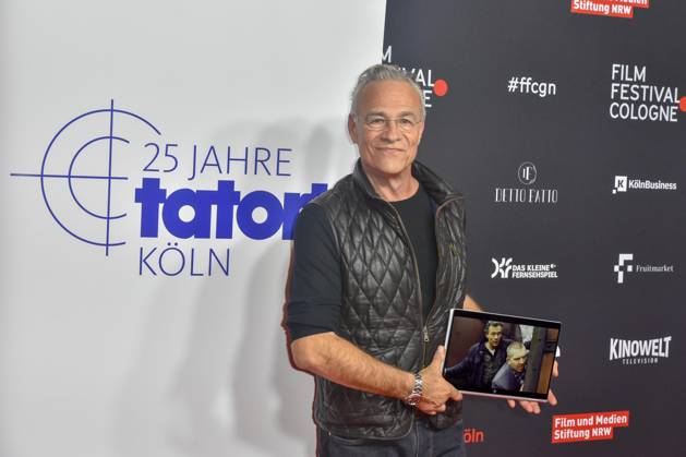 Klaus J. Behrendt Schauspieler mit Foto des abwesenden Kollegen Dietmar Baer auf dem roten Teppich bei der Premiere des ARD TAtort Spur des Blutes beim Film Festival Cologne, 25 Jahre Tatort Koeln vom WDR im Filmpalast Koeln am Freitag 21.Oktober 2022 NRW Deutschland