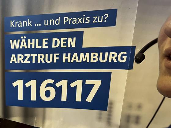 Symbolfoto - Wirtschaft -1 Hiweisschild 116117 Blau Weisses Hinweis Plakat mit der Notrufnummer 116117 haengt an der wand einer Arzt Paxis in Hamburg Der Arztruf Hamburg, das erweiterte Bereitschaftsdienst- und Service-Konzept der Kassenärztlichen Vereinigung Hamburg KVH bietet unter der bundeseinheitlichen Telefonnummer 116 117 den Menschen in Hamburg schnelle ambulante ärztliche Hilfe HH Deutschland