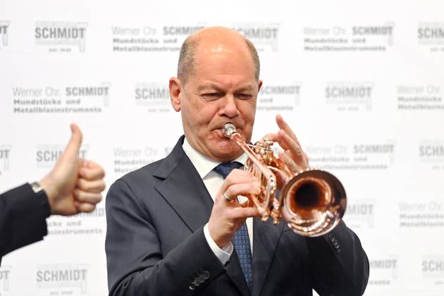 Bilder des Jahres 2025, News 03 März News Themen der Woche KW11 News Bilder des Tages Messerundgang Bundeskanzler Olaf SCHOLZ, bei einem Stand einer Firma fuer Metallblasinstrumente, spilelt mit einer Jazz Trompete. Spitzengespraech der Deutschen Wirtschaft am 14.03.2025 anlaesslich Internationale Handwerksmesse IHM Muenchen