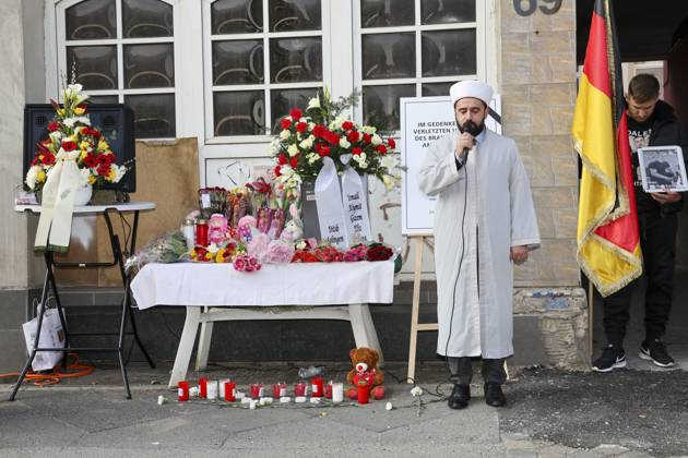 Bilder des Jahres 2025, News 03 März News Themen der Woche KW13 News Bilder des Tages Gedenkfeier 1 Jahr nach dem Brandanschlag auf das Mietshaus, wo die junge tuerkische Familie Zhilova ums Leben kam 25.03.2025, Solingen, Gruenewalder Strasse, Gedenkfeier 1 Jahr nach dem Brandanschlag wo eine 4 Koepfige Familie Zhilova ums leben kam im Bild: Gedenkstunde, ein Jahr nach dem Brandanschlag auf der Gruenewalder Strasse mit der türkischen-islamischen Gemeinde Ditib vor dem Haus stehen Mahnwachen mit den Namen und Bildern der ums Leben gekommenen Familie Zhilova und ein Tisch mit Blumen, Grablampen und Stofftieren, der Imam der türkisch islamischen Gemeinde Ditib betet Der Einzeltaeter wurde schnell gefasst, die Gerichtsverhandlungen laufen, es deutet alles auf Akt der Fremdenfeindlichkeit Fremdenhass hin.