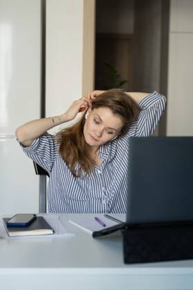 MR_ID27929_20617_TatyanaRangulova.jpg, PR_ID27929_10891_Cat.jpg, PR_ID27929_10892_Room.jpg Woman in a striped shirt at home, adjusting her earphones while working on a laptop. A phone, notebook, and pen are on the table, creating a cozy workspace., Property released Model Released LiliyaSolopova_ID27929_802077_017 Copyright: xLiliyaxSolopovax