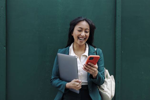 Creative Highlights Symbolfotos Businesswoman smiling while using smartphone outdoors model released, Symbolfoto, ASGF06292