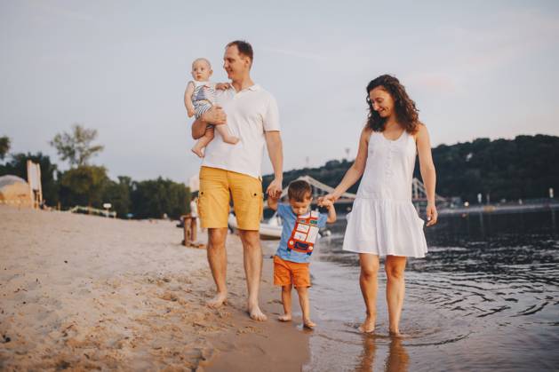 Familienurlaub im Sommer. Junge kaukasische Familie Fuß zu Fuß barfuß Sandstrand, Ufer Fluss Wasser. Papa Mama hält Hände zwei Kinder, Brüder. Große freundliche Familie mit zwei Kindern in der Nähe von See Family holiday in summer. Young Caucasian family foot walking barefoot sandy beach, shore river water. Dad mom holding hands two children, brothers. Big friendly family with two children near lake Copyright: imageBROKER fotoliza.ua ibxiqx13296583.jpg ,model released, Symbolfoto ,property released