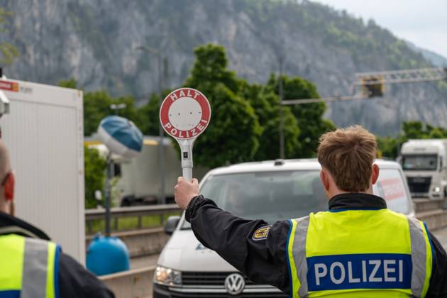 Grenzkontrolle der Bundespolizei an der Kontrollstelle Kiefersfelden, Inntal Ost, an der Autobahn A93 zwischen Deutschland und Österreich. Ein Polizist hält auf der Autobahn eine Polizeikelle mit Aufschrift HALT POLIZEI