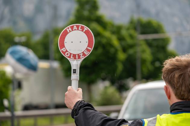 Grenzkontrolle der Bundespolizei an der Kontrollstelle Kiefersfelden, Inntal Ost, an der Autobahn A93 zwischen Deutschland und Österreich. Ein Polizist hält auf der Autobahn eine Polizeikelle mit Aufschrift HALT POLIZEI