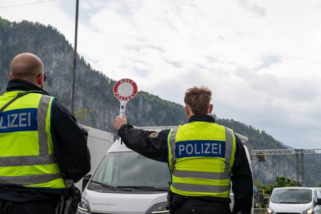 Grenzkontrolle der Bundespolizei an der Kontrollstelle Kiefersfelden, Inntal Ost, an der Autobahn A93 zwischen Deutschland und Österreich. Ein Polizist hält auf der Autobahn eine Polizeikelle mit Aufschrift HALT POLIZEI
