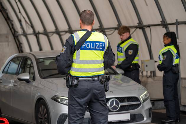 Grenzkontrolle der Bundespolizei an der Kontrollstelle Kiefersfelden, Inntal Ost, an der Autobahn A93 zwischen Deutschland und Österreich. Polizeibeamte bzw. Polizisten kontrollieren ein Fahrzeug in einem Kontrollzelt