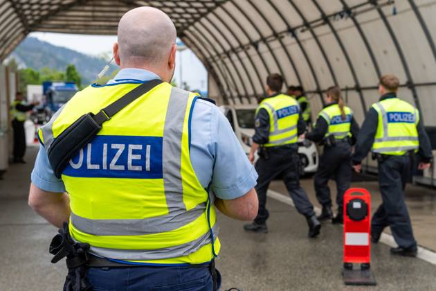 Grenzkontrolle der Bundespolizei an der Kontrollstelle Kiefersfelden, Inntal Ost, an der Autobahn A93 zwischen Deutschland und Österreich. Polizist steht vor einer Grenzkontrollstation zur sicherung der Kollegen