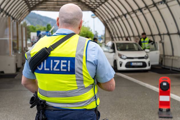 Grenzkontrolle der Bundespolizei an der Kontrollstelle Kiefersfelden, Inntal Ost, an der Autobahn A93 zwischen Deutschland und Österreich. Polizist steht vor einer Grenzkontrollstation zur sicherung der Kollegen